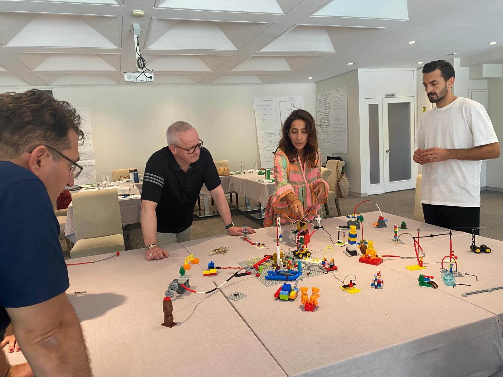 A group at work around a table covered with individual LEGO models