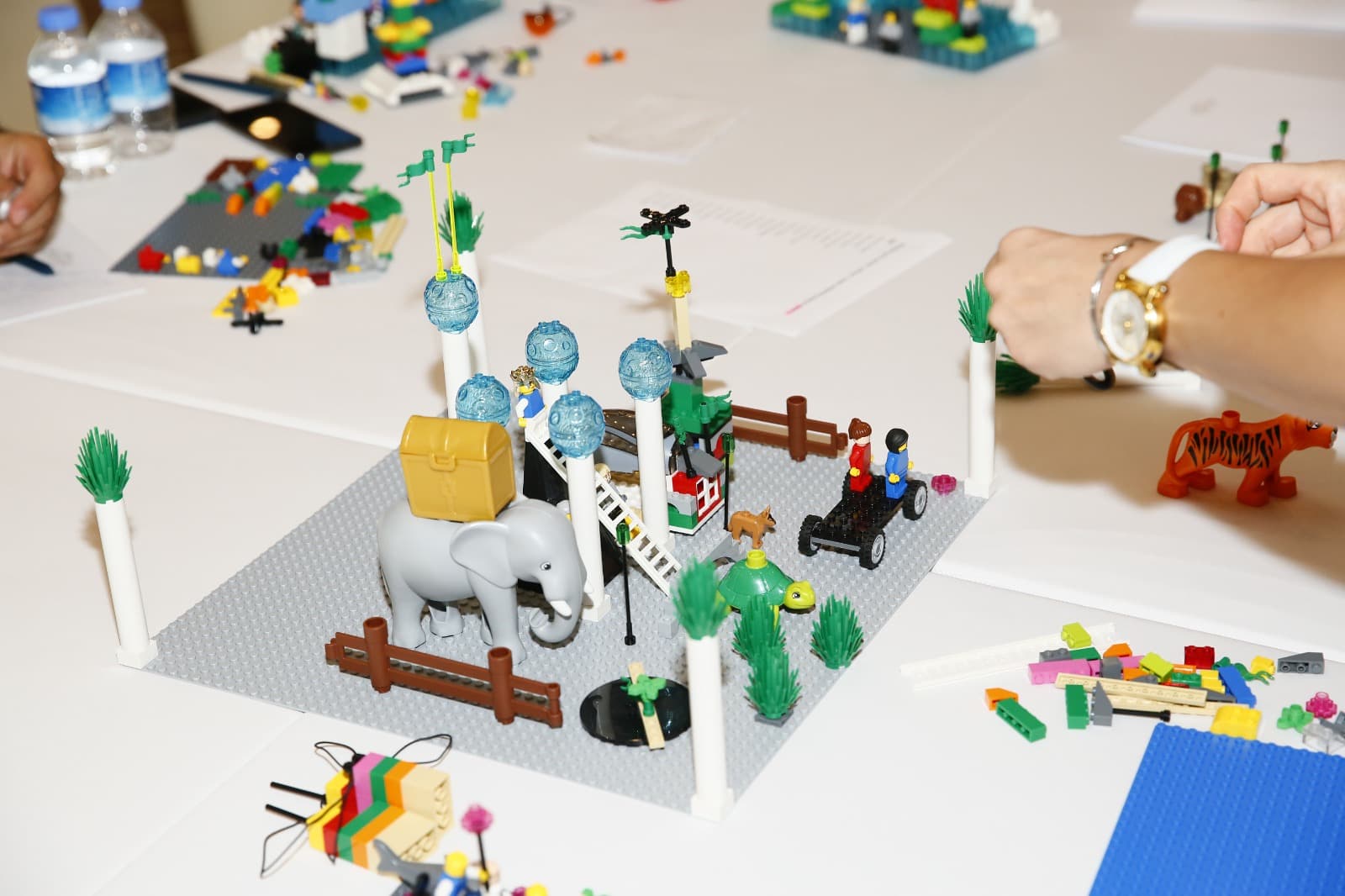 A shared LEGO landscape with an elephant, figures and greenery on a base plate